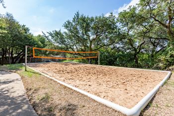 a volleyball court at the whispering winds apartments in pearland, tx at The Verandah, Austin, 78726